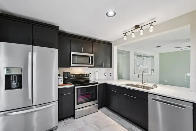 a large kitchen with a refrigerator stove and sink