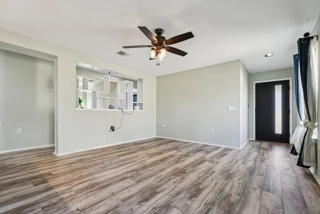 a view of a livingroom with wooden floor and a ceiling fan