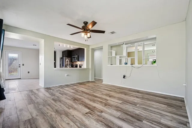 a view of a livingroom with wooden floor and a ceiling fan