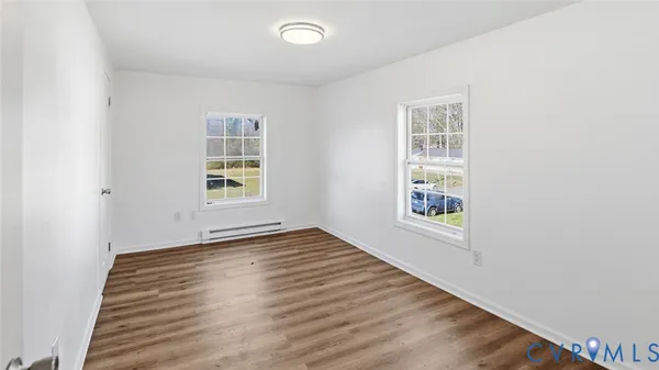 a view of an empty room with wooden floor