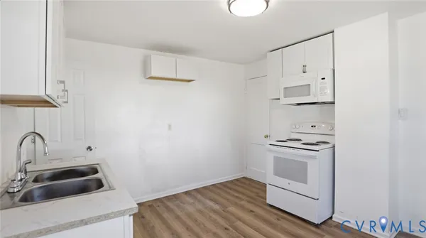 a kitchen with a stove and white cabinets