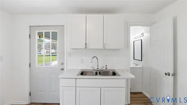 a kitchen with granite countertop a sink cabinets and stainless steel appliances