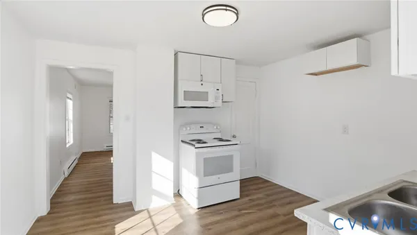 a kitchen with a sink cabinets and wooden floor