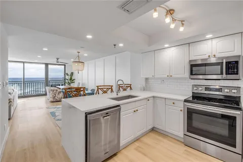 a kitchen with stainless steel appliances granite countertop a sink a stove and a refrigerator