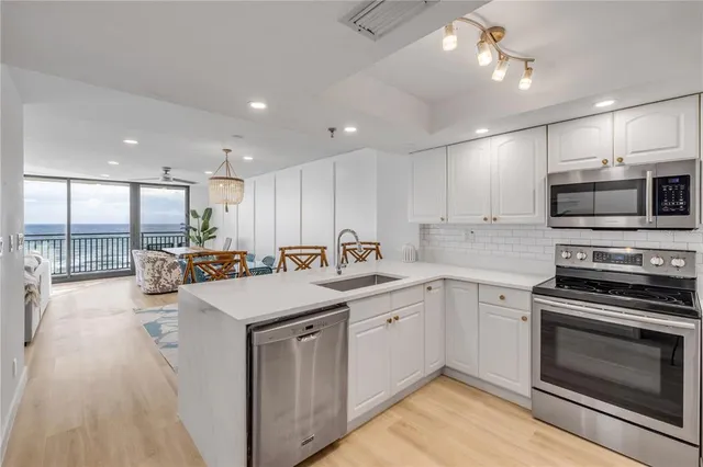 a kitchen with stainless steel appliances granite countertop a sink a stove and a refrigerator