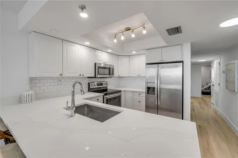a living room with furniture a flat screen tv and kitchen view
