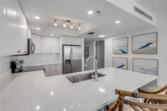 a kitchen with a sink stainless steel appliances and cabinets
