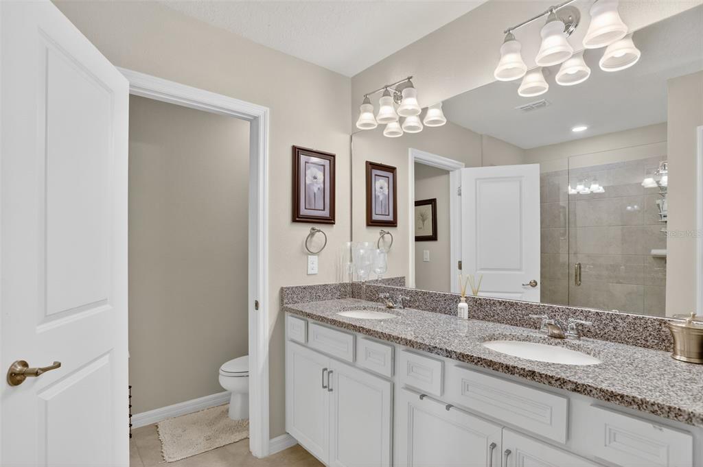 2222 Gopher Tortoise Terrace Oakland, FL 34787 - Photo 28 of 51 a bathroom with a granite countertop sink a toilet and a mirror