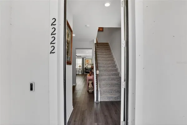 a view of a hallway with wooden floor and entryway