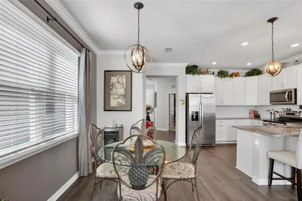 a view of a dining room and livingroom with furniture wooden floor a chandelier