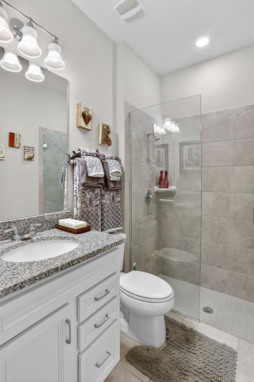 2222 Gopher Tortoise Terrace Oakland, FL 34787 - Photo 8 of 51 a bathroom with a granite countertop sink a toilet and shower