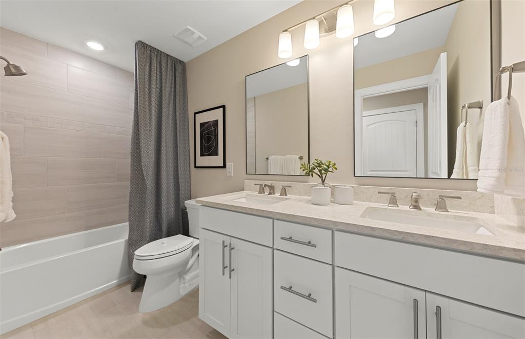 16427 Sapphire Point Drive Lakewood Ranch, FL 34211 - Photo 24 of 30 a bathroom with a double vanity sink toilet mirror and bathtub