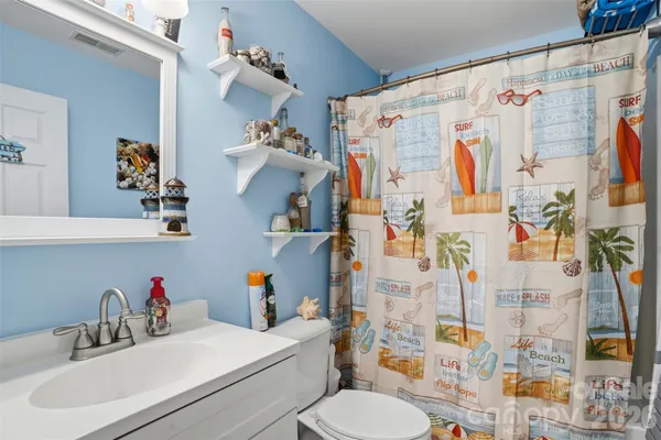 a bathroom with a sink vanity mirror and toilet