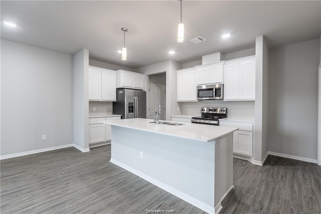 1326 Prairie Drive, Unit 623 Bryan, TX 77803 - Photo 4 of 21 a kitchen with kitchen island a sink stainless steel appliances and cabinets