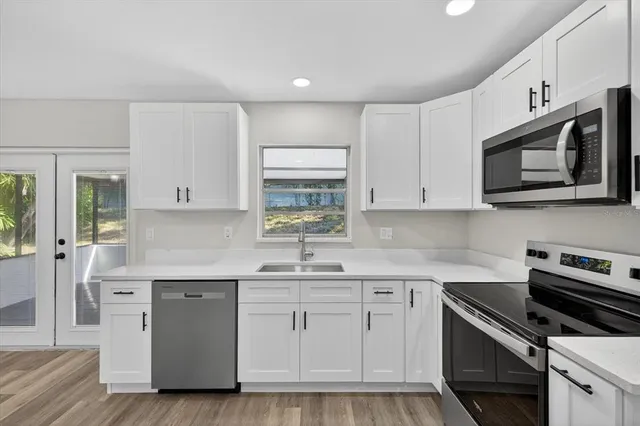 a kitchen with stainless steel appliances granite countertop a sink a stove a microwave and cabinets