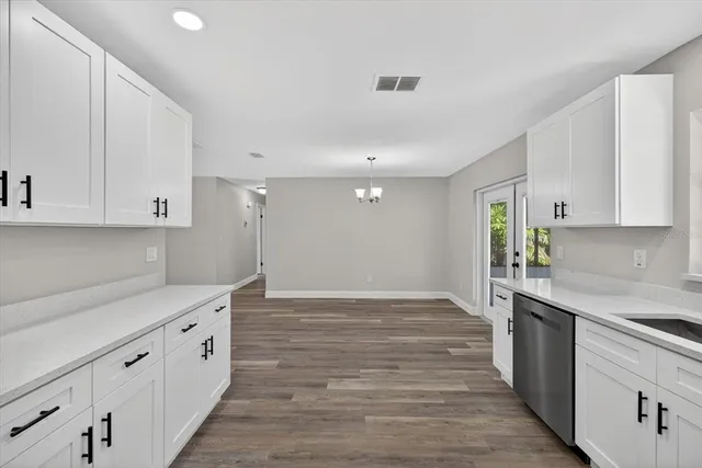 a kitchen with cabinets wooden floor and stainless steel appliances