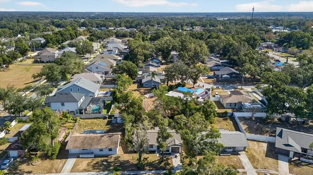 an aerial view of a house with a yard and large trees