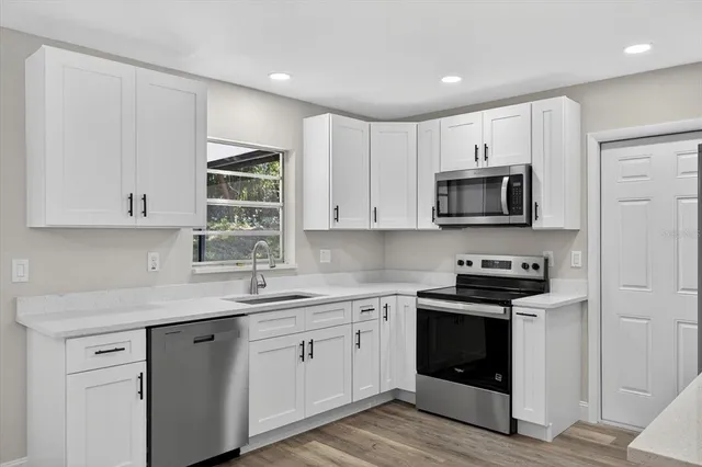 a kitchen with stainless steel appliances white cabinets and a sink