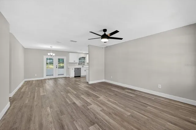 a view of a room with wooden floor and a ceiling fan