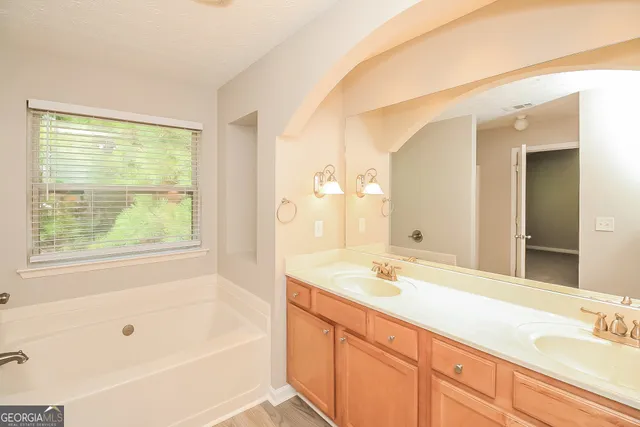 a bathroom with a tub sink and mirror