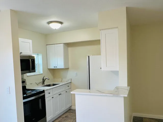 a kitchen with stainless steel appliances granite countertop a sink and a stove