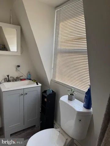 a bathroom with a sink and mirror with toilet
