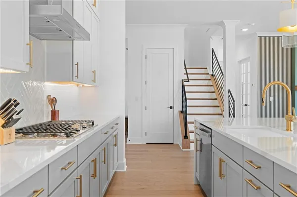 a kitchen with stainless steel appliances granite countertop a stove a sink and a window