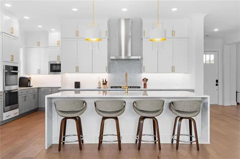 a kitchen with white cabinets and sink
