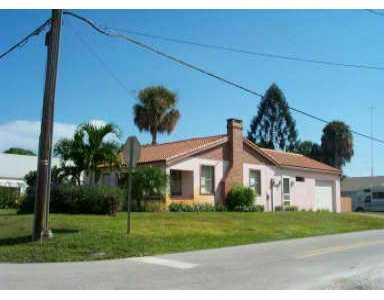 661 Southwest Bryant Avenue Stuart, FL 34994 - Photo 1 of 1 a front view of a house with a yard and garage
