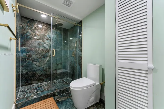 a bathroom with a toilet and a shower
