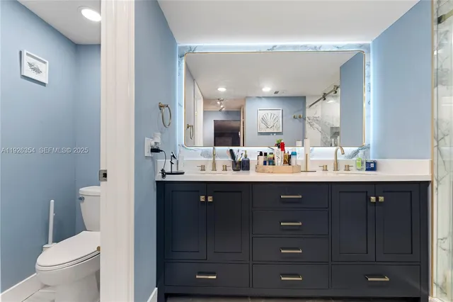 a bathroom with a double vanity sink toilet and a mirror
