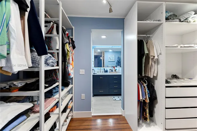 a view of walk in closet with clothes and shoes
