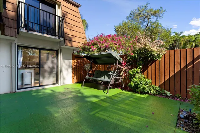 a view of a chair and table in backyard of the house