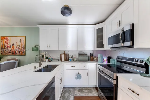 a kitchen with a sink a stove and cabinets