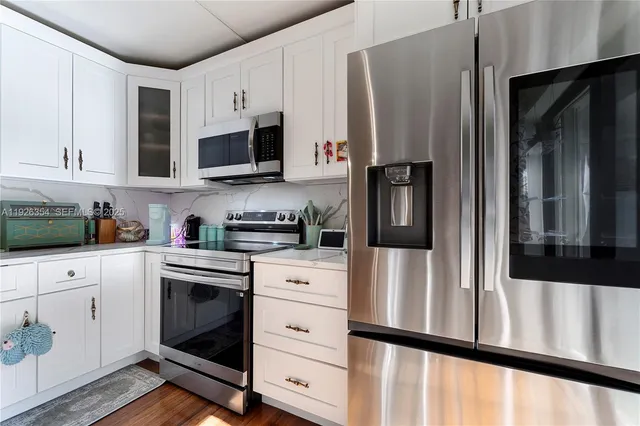 a kitchen with stainless steel appliances white cabinets and a refrigerator