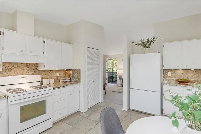 a kitchen with a refrigerator and a stove top oven