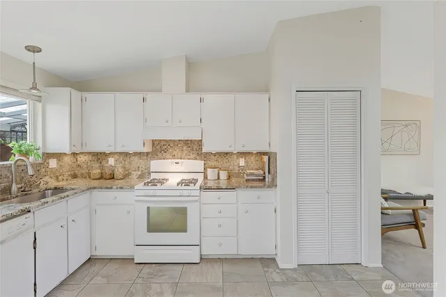 a kitchen with white cabinets and white appliances