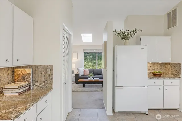 a kitchen with a refrigerator sink and cabinets