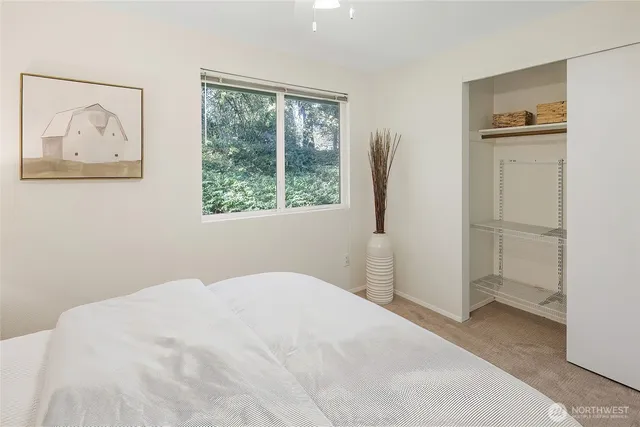 a bedroom with a bed and a painting on the wall