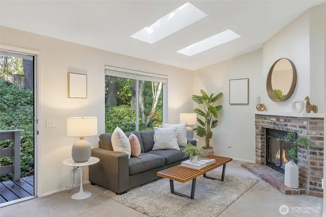a living room with furniture a fireplace and a floor to ceiling window