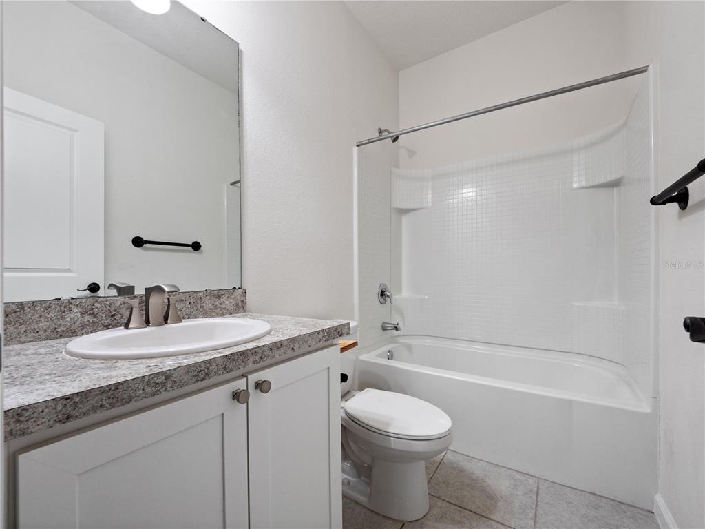 2249 Litchfield Loop DeLand, FL 32720 - Photo 20 of 27 a bathroom with a granite countertop sink a toilet and a bathtub