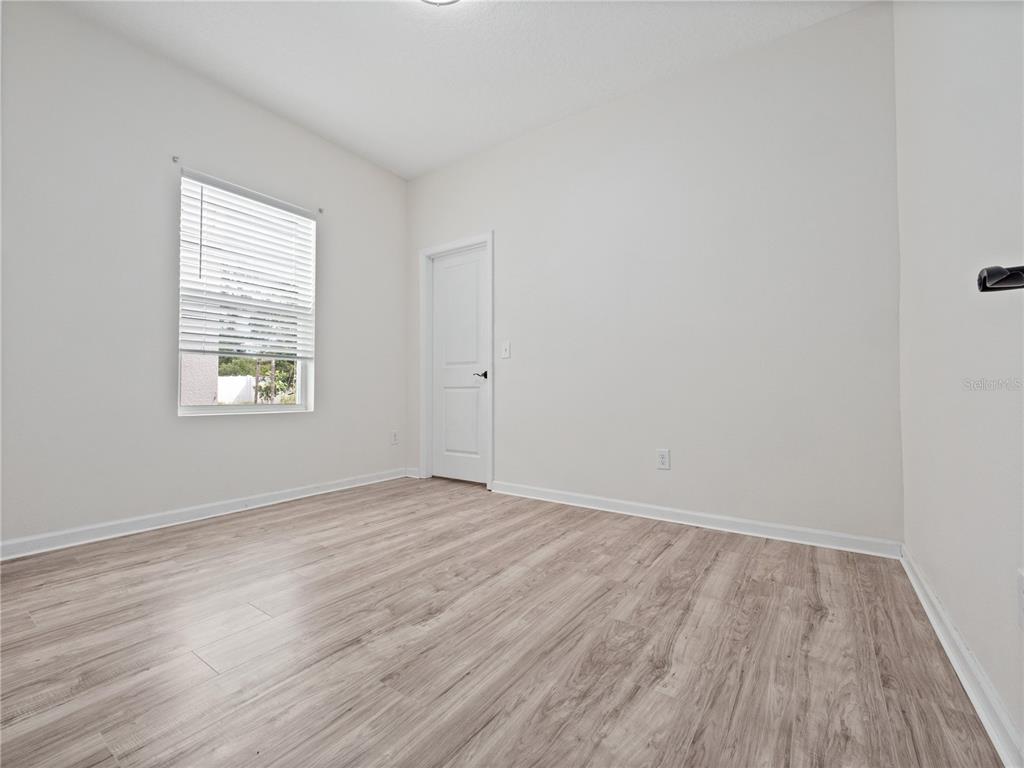2249 Litchfield Loop DeLand, FL 32720 - Photo 21 of 27 wooden floor in an empty room with a window