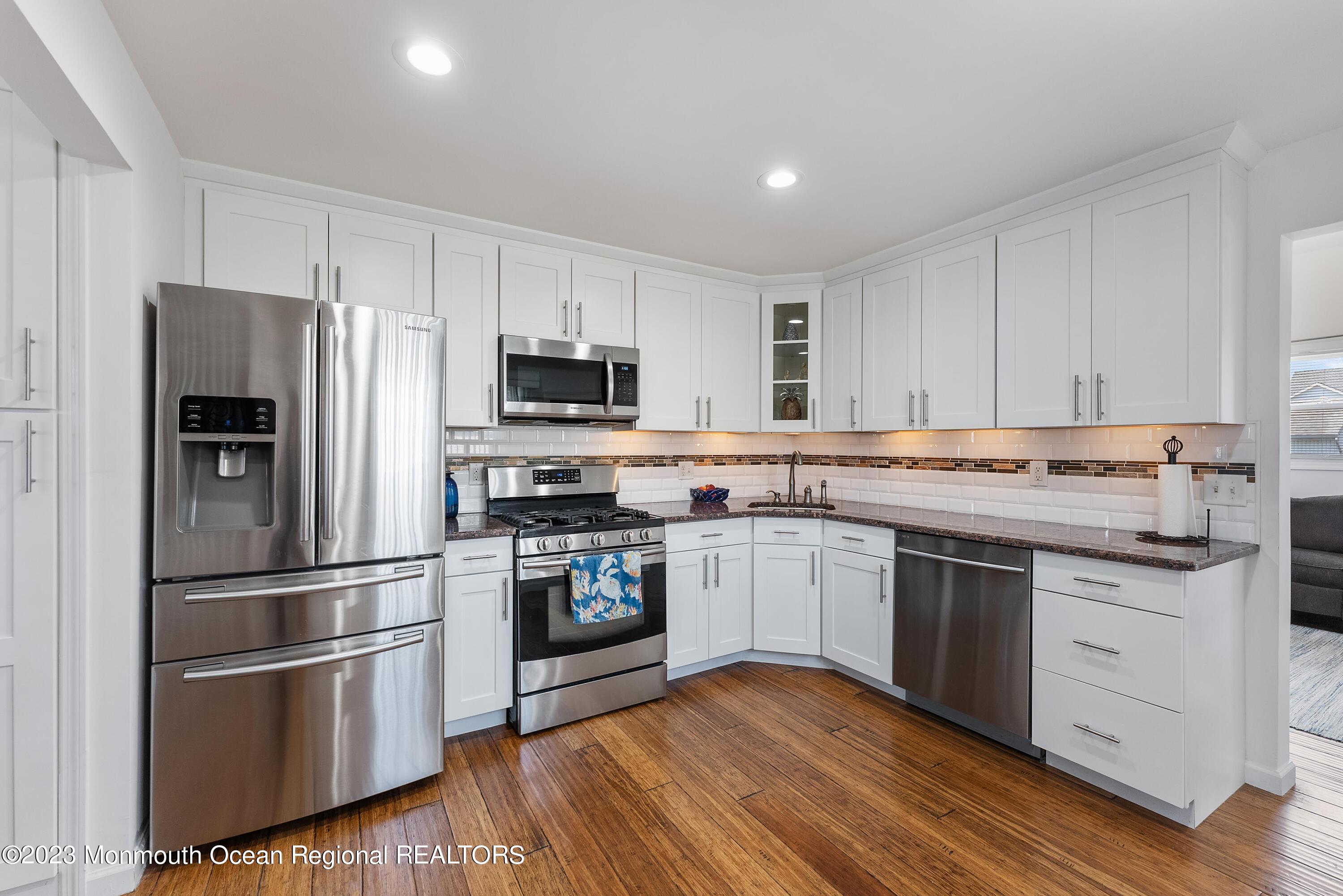 16 Brookfield Drive Brick, NJ 08723 - Photo 11 of 37 a kitchen with granite countertop white cabinets stainless steel appliances and wooden floor