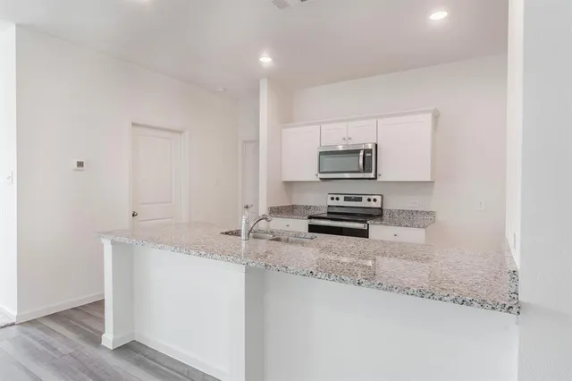 a kitchen with granite countertop a stove and a sink