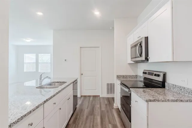 a kitchen that has a sink and wooden floor