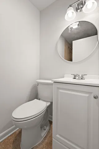 a white toilet sitting next to a bathroom sink and a mirror