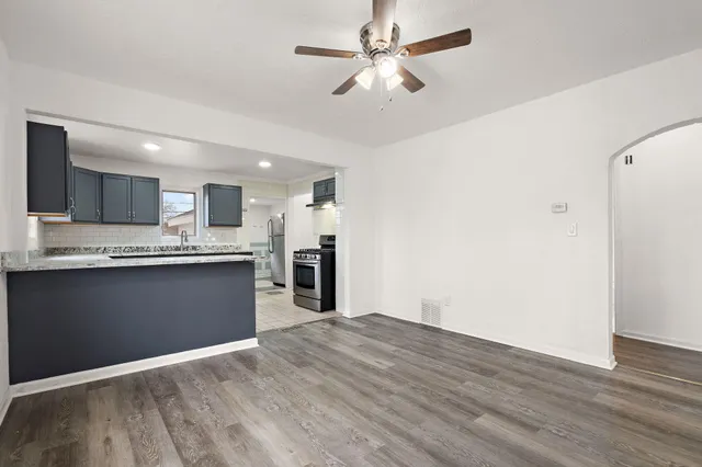a view of kitchen with granite countertop cabinets and refrigerator