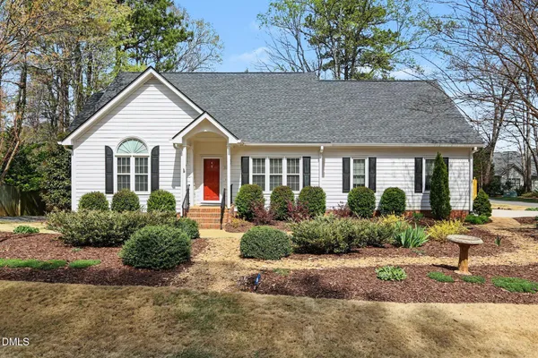 a front view of a house with a yard and potted plants