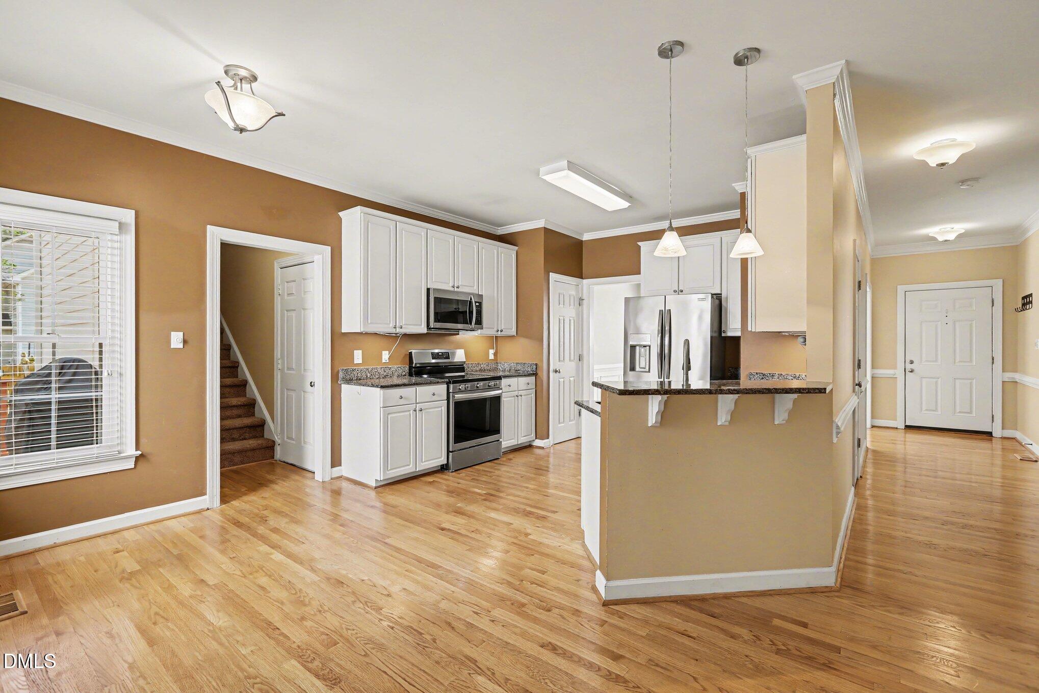 2616 Jasper Lane Raleigh, NC 27613 - Photo 12 of 44 a kitchen with stainless steel appliances granite countertop a refrigerator a sink a stove top oven and a wooden floors