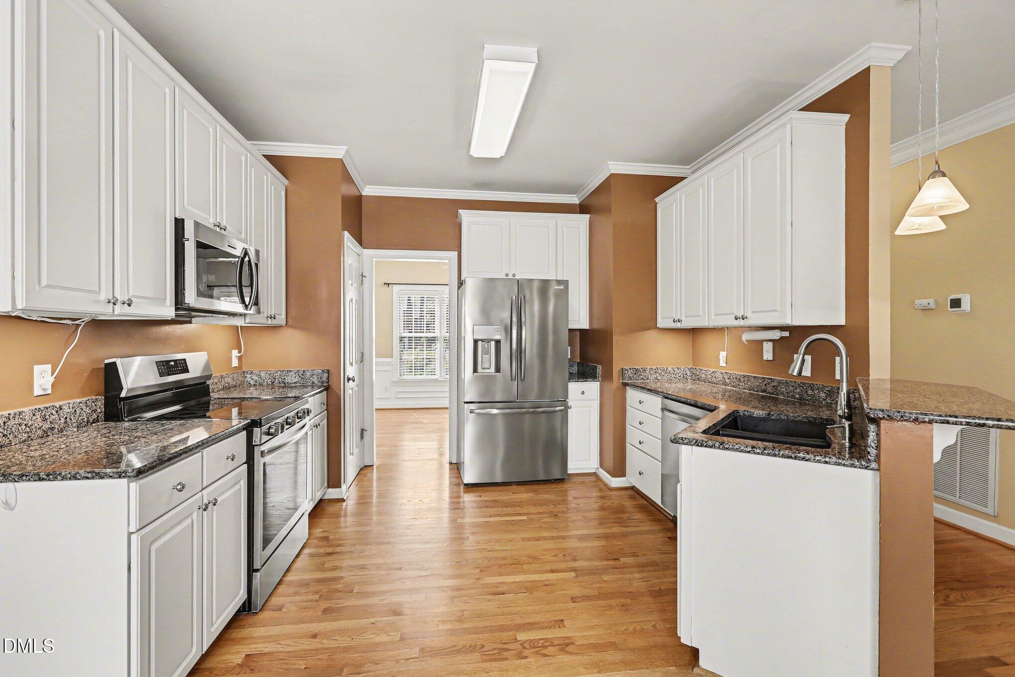 2616 Jasper Lane Raleigh, NC 27613 - Photo 13 of 44 a kitchen with granite countertop a refrigerator stove top oven and sink